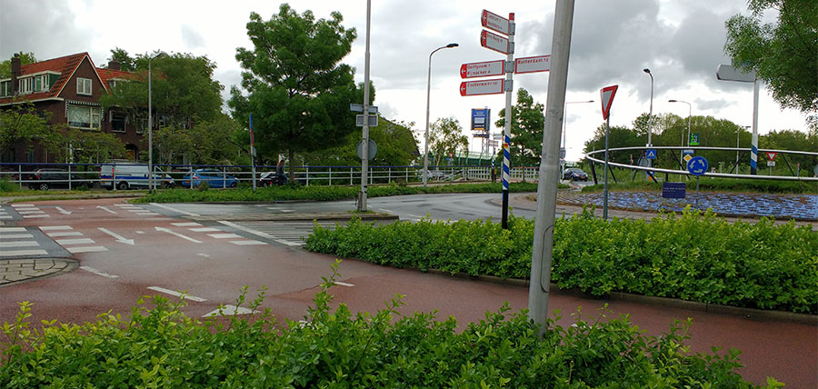 A roundabout design common in the Netherlands where bicycle and automobile traffic is separated. Vehicles travel in the centermost lanes and bicycles use the outer, red-colored lanes. Striping instructs car drivers to yield to bike traffic as they enter the roundabout.