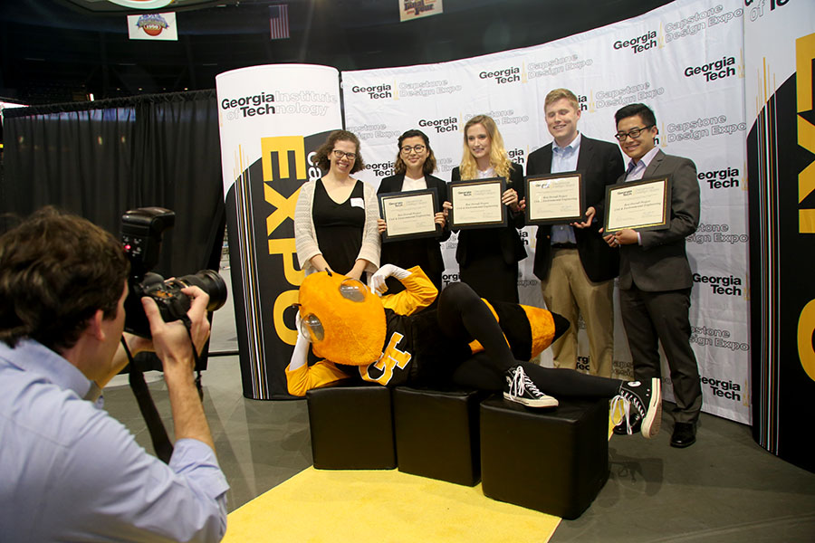 Team Stryd Transportation poses for a photo just after they learned they had won first place among School of Civil and Environmental Engineering's teams at the spring 2016 Capstone Design Expo. They designed a roundabout for0 a tricky intersection at Holly Springs and Old Canton roads in Cobb County, Georgia. Pictured from left to right, Assistant Professor Kari Watkins, who presented the award, and team members Lilian Ayala, Sage Roberts, John Bolen and Ryan Liu. The big guy in the front is, of course, Buzz. (Photo: Joshua Stewart)