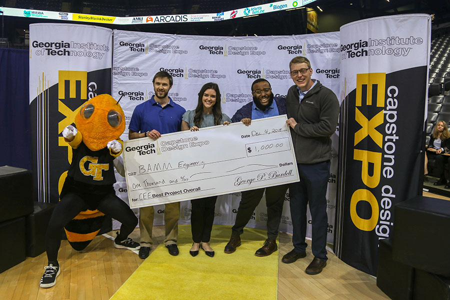 The BAMM Engineering senior design team won top prize among the 18 civil and environmental engineering groups at the fall 2018 Capstone Design Expo Dec. 4. Team members with Buzz at the expo awards ceremony: Michael Nieman, left, Bailey Little, Andrew White and Matthew Gruba. (Photo: Amelia Neumeister)