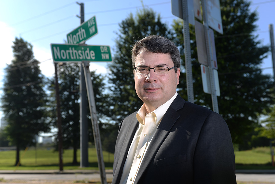 Associate Professor Michael Hunter stands along North Avenue, the City of Atlanta's new "smart corridor." Along with the city, the Georgia Department of Transportation and other partners, Hunter will help cut the ribbon for the corridor Sept. 14. Along with Randall Guensler, Hunter is using smart technology data collected along the corridor by cameras, road sensors, traffic signals, and connected vehicles to understand the impact of traffic signal timing and driver behavior on energy use and emissions. (Photo: Chris Moore)