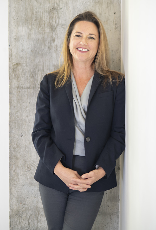 Professor Kimberly Kurtis stands next to a concrete column in the Mason Building Lobby.