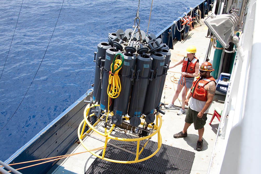 Researchers Liz Robertson from the University of Southern Denmark and Josh Manger from the University of California, San Diego, ready a sample collector off Mexico's Pacific coast. They’re part of a research team that discovered bacteria making oxygen minimum zones in the ocean even deader by sucking up all life-giving nitrogen molecules. (Photo: Heather Olins)