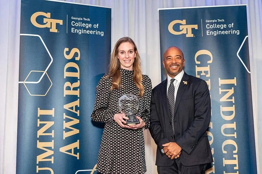 A woman holding an award poses with a man