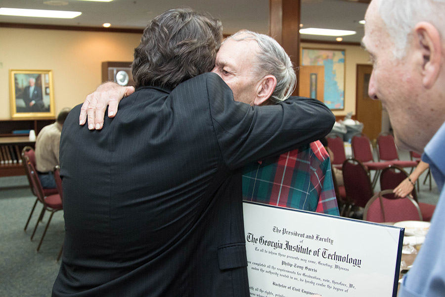 Philip Sarris hugs School of Civil and Environmental Engineering Professor Aris Georgakakos after Sarris received the diploma her earned in 1952. Sarris didn't participate in Commencement after he finished his degree because he was drafted and sent off to Korea. (Photo: Scott Dinerman)
