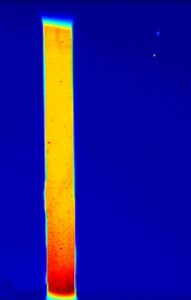 Time-lapse video showing the variation in surface temperature of a shape-memory alloy experiencing loading and unloading. By inputting this information into a thermo-mechanical model, Georgia Tech researchers were able to accurately predict internal temperature and stress distributions for the material, which is being investigated for use in constructing seismic-resistant structures. (Click image to watch the video. Credit: Reza Mirzaeifar)