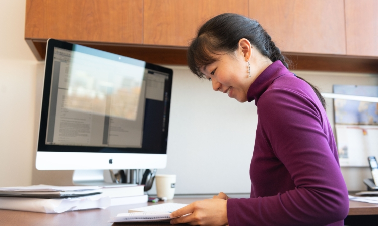 Iris Tien looking at papers on her desk 