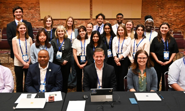 A large group of students and industry professionals pose for a group photo