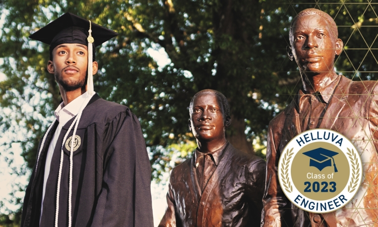 A man in a cap and gown stands next to two bronze statues 