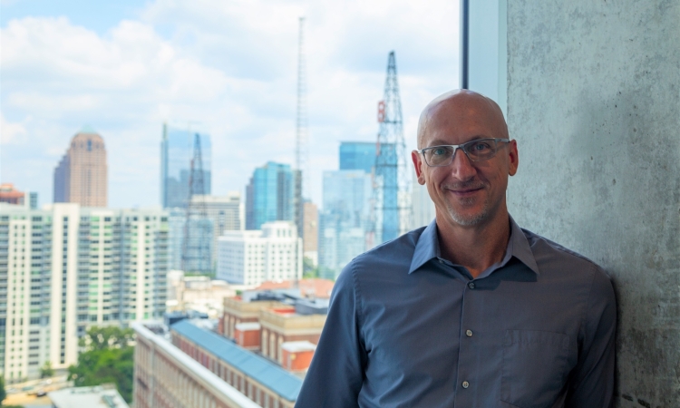 A portrait of a man in front of a city skyline 