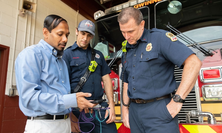 Angshuman Guin demonstrates how a cell phone tracks Gwinnett County Fire Department trucks and data about traffic to improve response times. Guin is working with Gwinnett on connected vehicle technology as part of the first round of Georgia Tech’s Georgia Smart Communities Challenge. (Photo: Allison Carter)