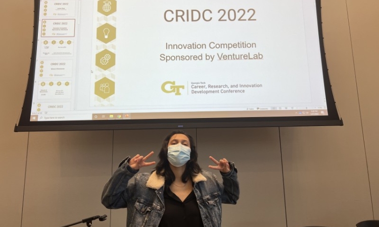 Mourin Jarin poses in front of the 2022 VentureLab Innovation Competition sign at the award ceremony. 
