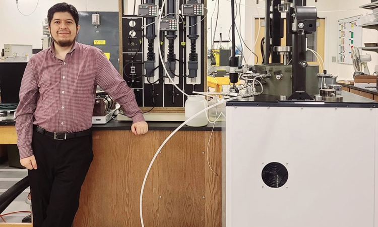 A man poses in front of laboratory equipment