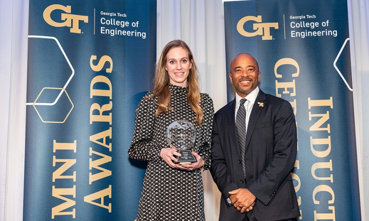 A woman holding an award poses with a man 