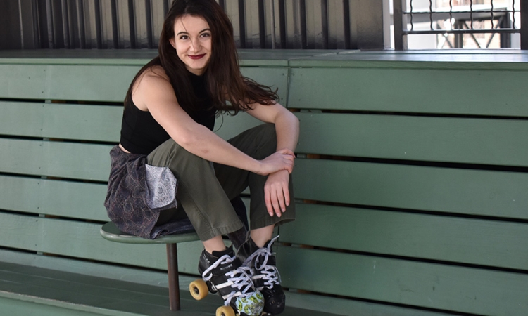 Guiliana Stovall sits on a bench with her roller derby roller skates. Stovall, a long-time roller derby player, knew she would continue to skate when she came to Georgia Tech. And since Tech had no outlet, she founded Yellow Jacket Roller Derby. (Photo Courtesy: Giuliana Stovall)