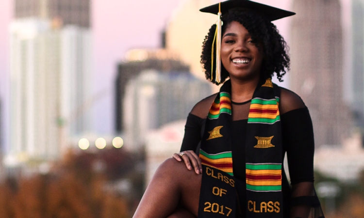 Sharani White poses in her cap and gown with Midtown Atlanta in the background. White struggled in her first year, to the point that she almost had to transfer. But now she's finished her civil engineering degree and has been accepted to graduate school. (Photo: Titilayo Funso)