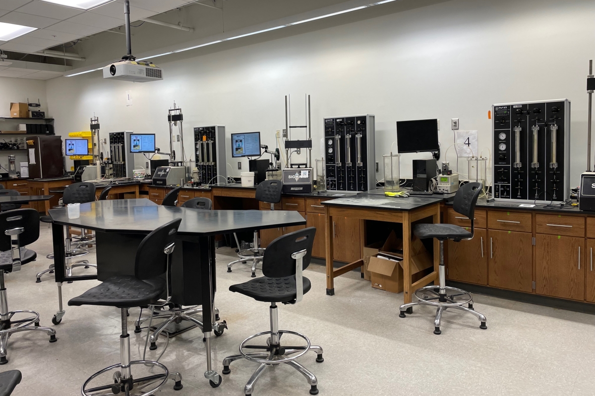 A classroom with computer screens and lab equipment 