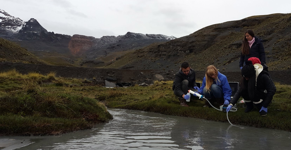 People collect water samples from a stream