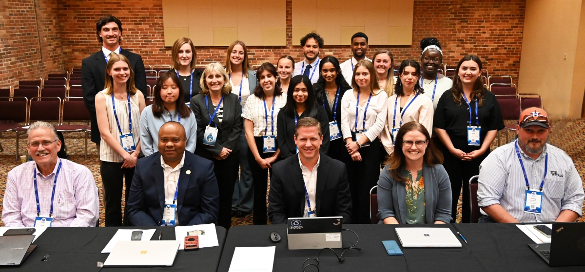 A group of students and industry professionals pose for a photo 