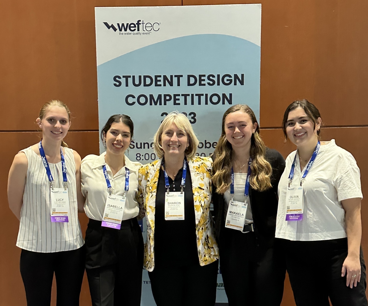 A group of women posing in front a sign reading student design competition 