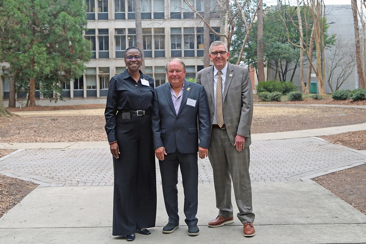 Associate chair Adjo Amekudzi-Kennedy, John Carroll and School Chair Don Webster standing in the courtyard behind the Mason Building