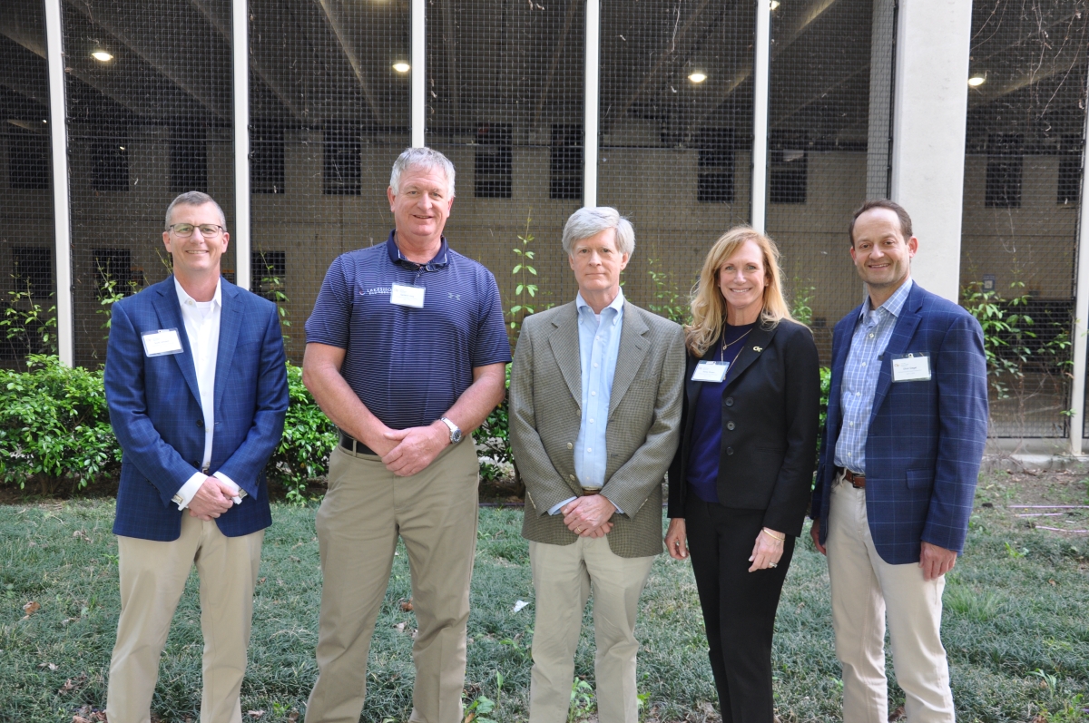 A group of four men and a woman stand in front of the Dalney parking garage. They are the judges for the 2026 Entrepreneurial Innovation Competition.