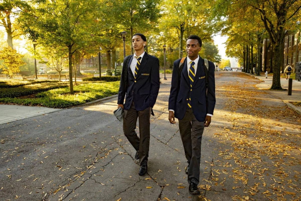 Two young people wearing suits and jackets walk on Georgia Tech campus