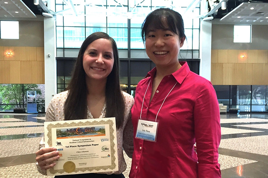 Chloe Johansen, left, and Iris Tien hold their first-place paper award at the Resilience Week 2017 conference for their work analyzing the vulnerabilities of interdependent infrastructure. They used Atlanta's water and power systems as a case study. (Photo Courtesy: Iris Tien)