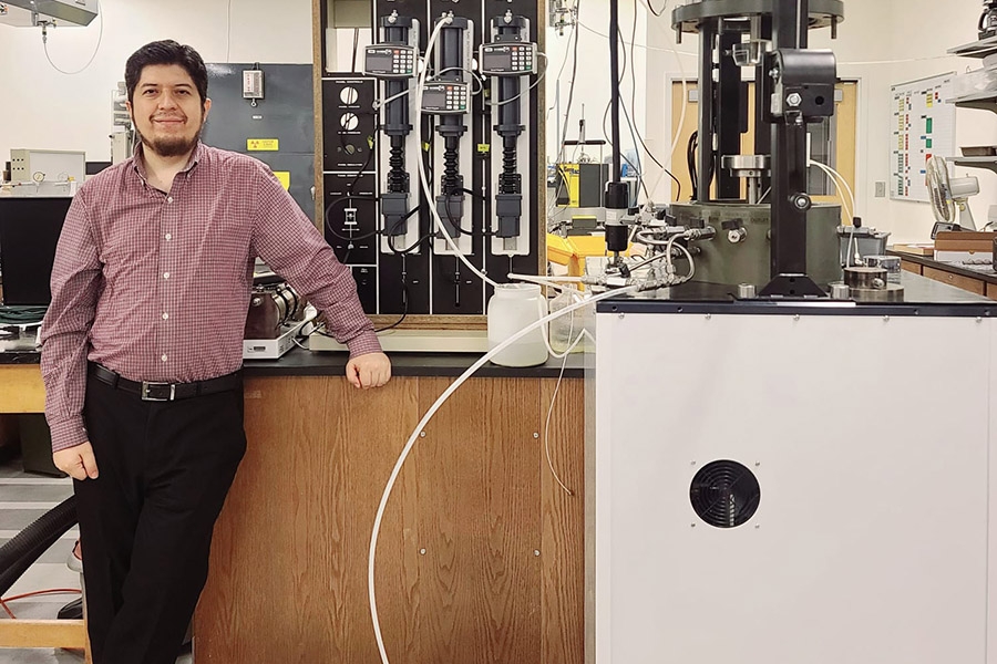 A man poses in front of laboratory equipment