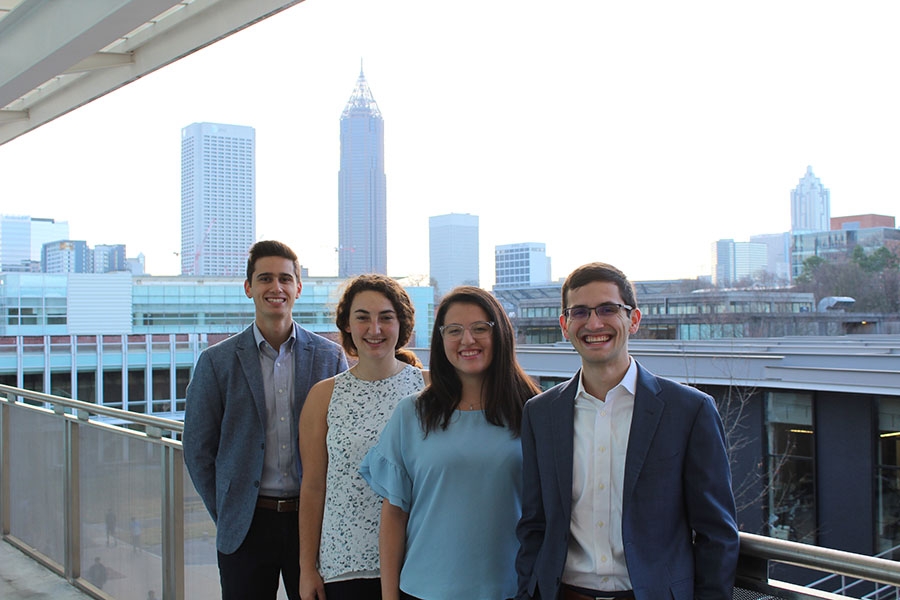 The four members of the student team River Recon pose in front of the Atlanta skyline