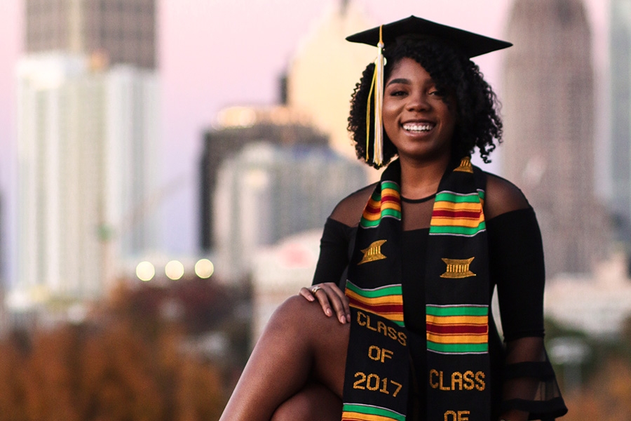 Sharani White poses in her cap and gown with Midtown Atlanta in the background. White struggled in her first year, to the point that she almost had to transfer. But now she's finished her civil engineering degree and has been accepted to graduate school. (Photo: Titilayo Funso)