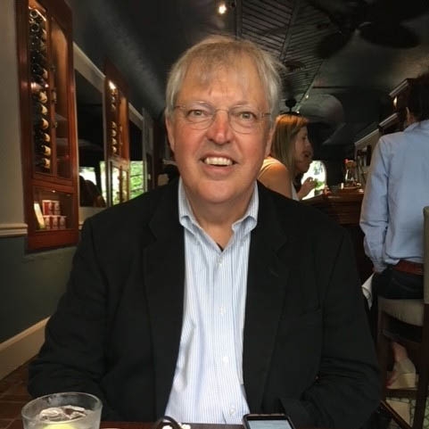 Portrait of Michael Messner in a navy blazer and a light blue dress shirt.